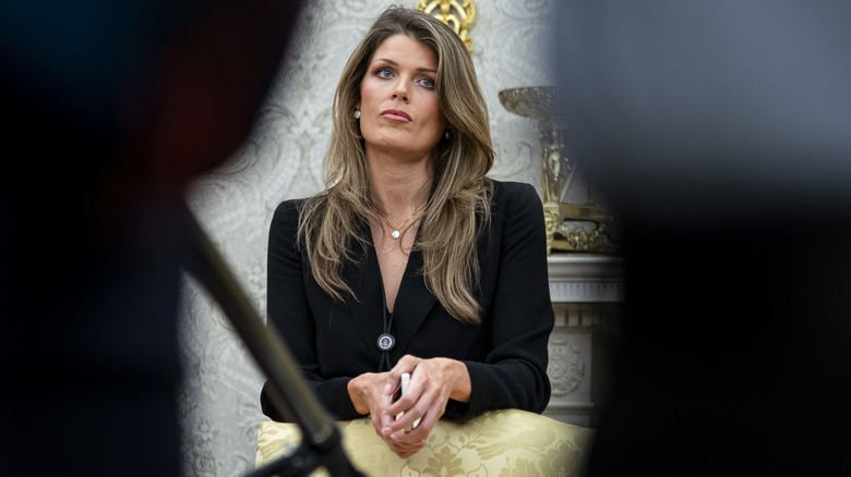 Lindsey Halligan overshadowed by two people in front of her