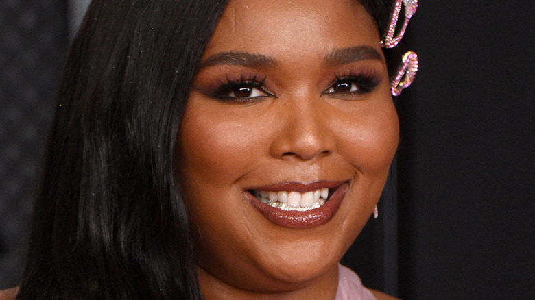 Lizzo smiling with bedazzled hair barrette