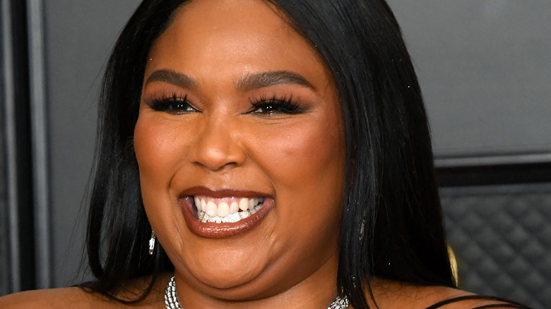 Lizzo smiling with bottom grills
