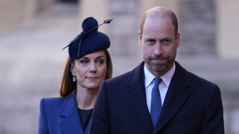 Kate Middleton and Prince William walking while looking downcast