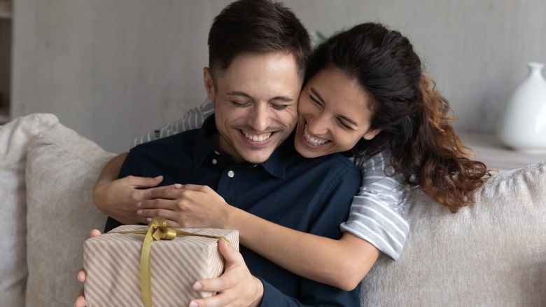 A woman surprising her partner with a gift