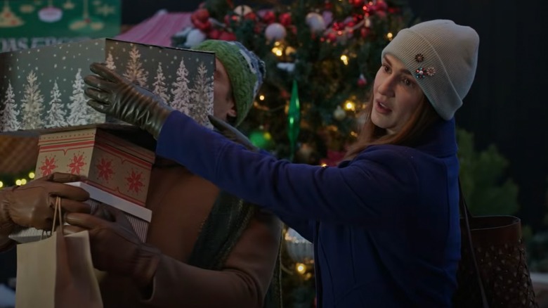 Katherine Barrell wearing a beanie and handling gifts in "O Little Christmas Market"