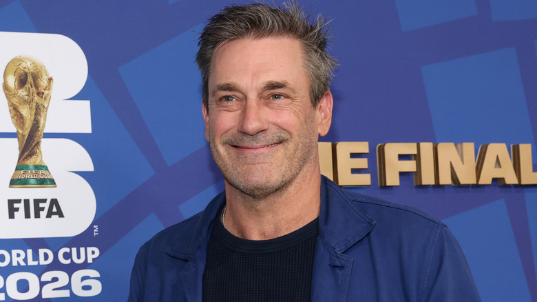 Jon Hamm in blue blazer smiling at FIFA World Cup