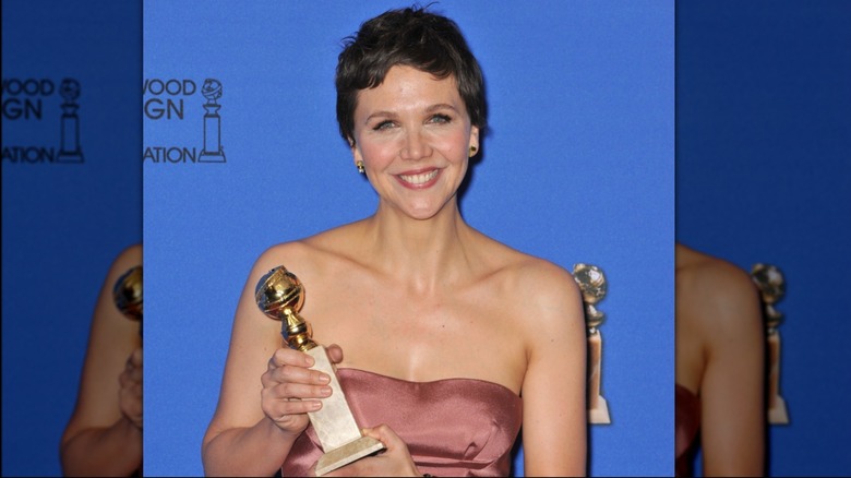 Maggie Gyllenhaal holding her Golden Globe.