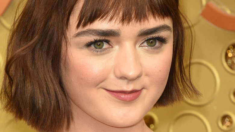 Maisie Williams grinning as a brunette in 2019