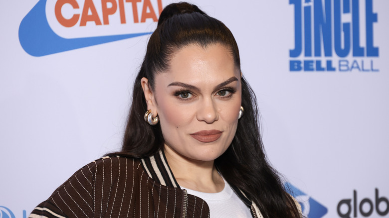 Jessie J in a brown varsity jacket and high ponytail