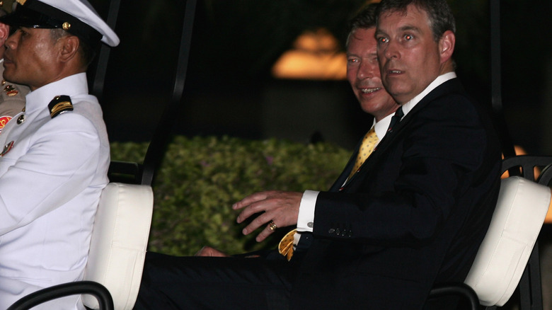 Prince Andrew riding in a vehicle at a royal club in Thailand
