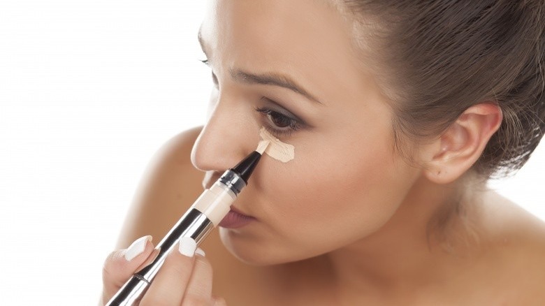 woman applying concealer