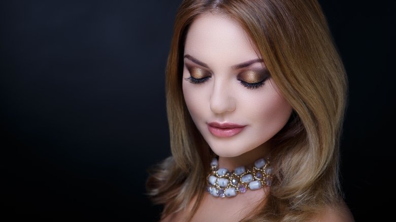 trendy woman with large necklace and bold eyeshadow