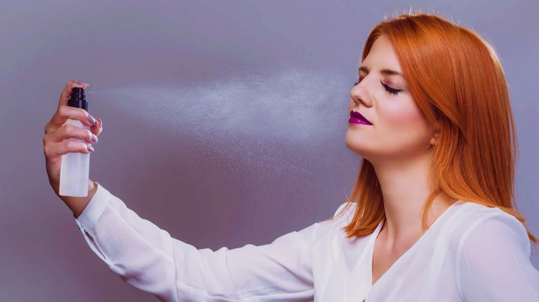 Woman applying makeup setting spray