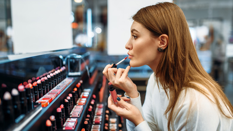 Customer putting on lip gloss 