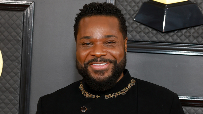 Malcolm-Jamal Warner smiling on the Grammys red carpet