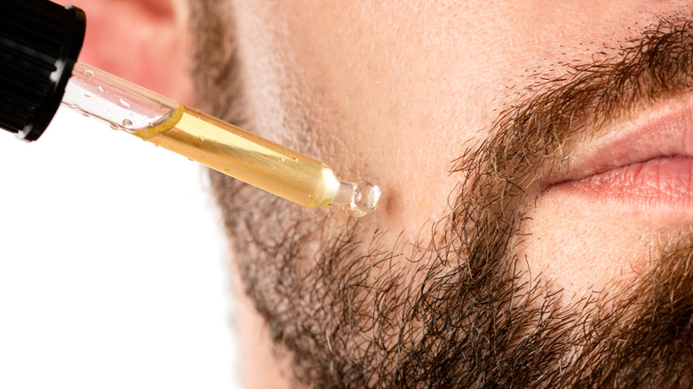 A serum being applied to a man's face 