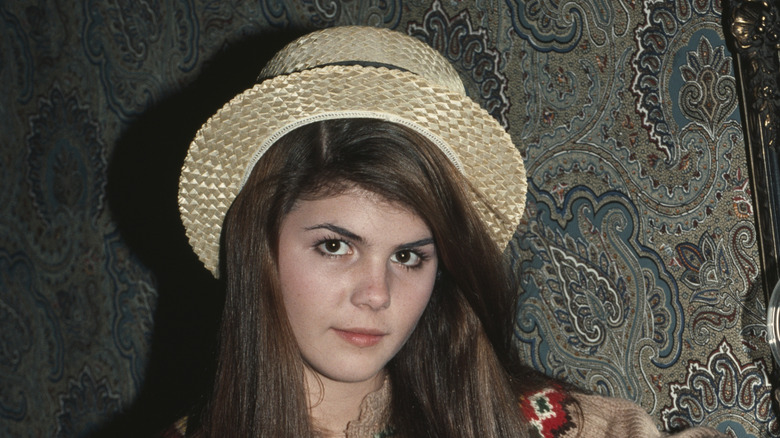 Lori Loughlin posing inside with a hat on
