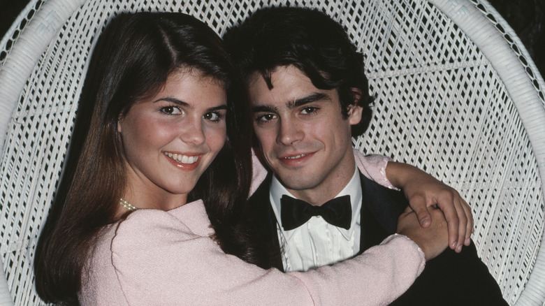 (l-r): Lori Loughlin and her "The Edge of Night" co-star Mark Arnold sitting down and smiling.