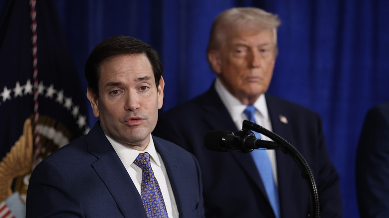 Marco Rubio speaking with Donald Trump standing behind him