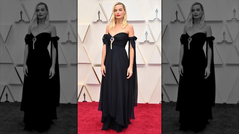Margot Robbie at the Academy Awards in 2020, wearing a black off the shoulder dress with bows on the sleeves