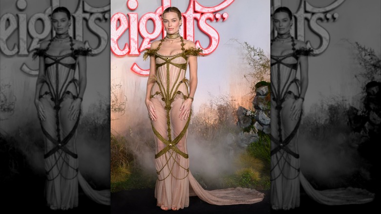 Margot Robbie at the "Wuthering Heights" UK premiere in 2026 wearing a structured, partially see through beige dress with green boning