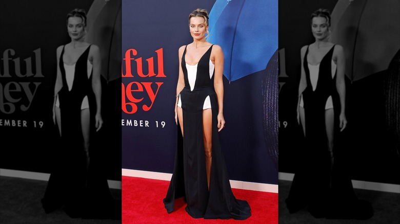 Margot Robbie at a premiere of "A Big Bold Beautiful Journey" wearing a black and white dress with high slits