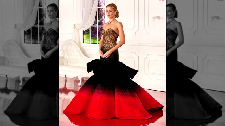 Margot Robbie at the world premiere of "Wuthering Heights" in 2026 wearing a dramatic lace, black, and red gown on the red carpet