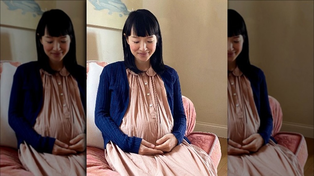 Marie Kondo holds her pregnant belly