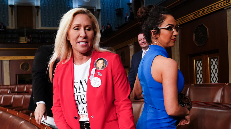 Lauren Boebert and Marjorie Taylor Greene moving past each other in the House