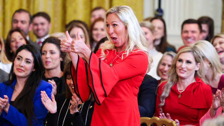 Marjorie Taylor Greene giving thumbs up in a crowd