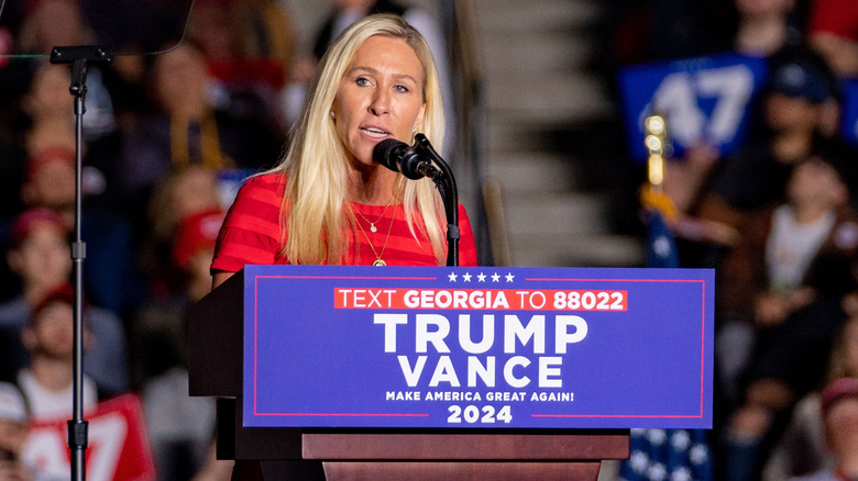 Marjorie Taylor Greene stands at a podium