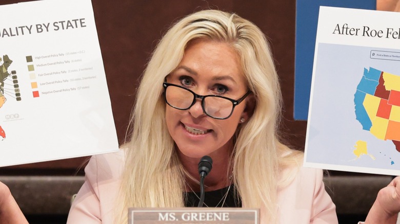 Marjorie Taylor Greene holds up maps during a DOGE Subcommittee meeting