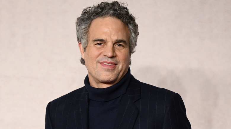 Mark Ruffalo smiling in a black turtleck against pale beige backdrop