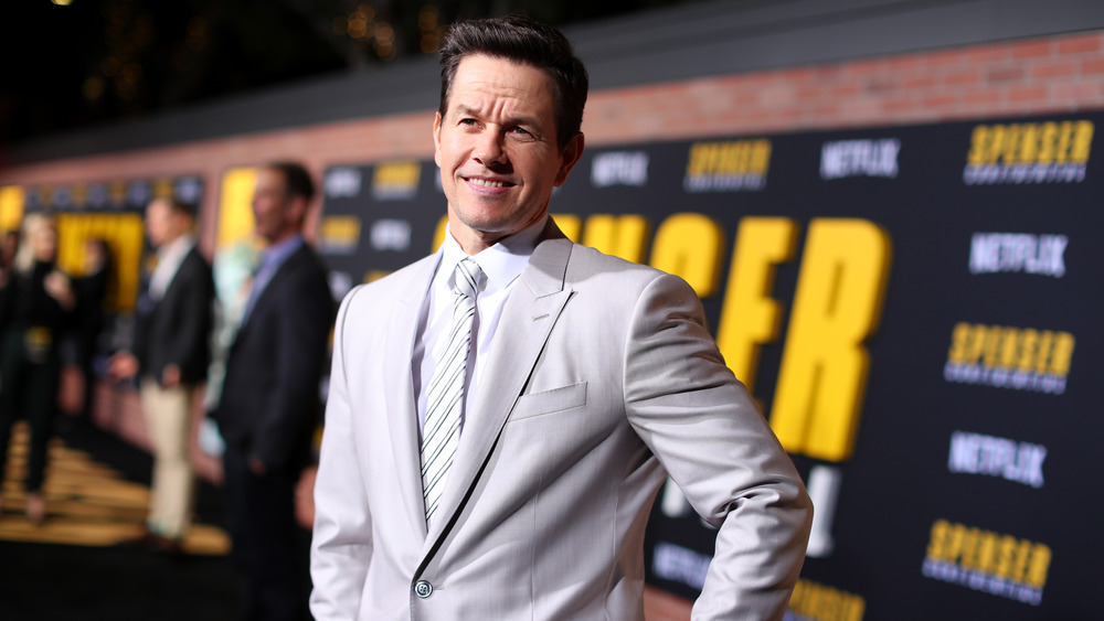 Mark Wahlberg posing at event in off-white suit