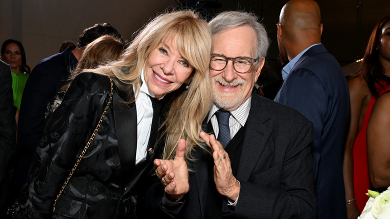 Steven Spielberg smiling and clapping with Kate Capshaw