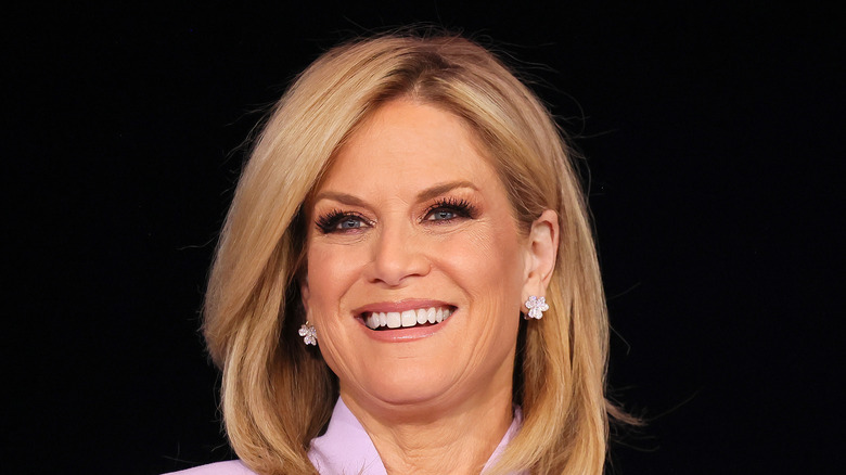 Martha MacCallum smiling in a purple jacket at Fox News studios.