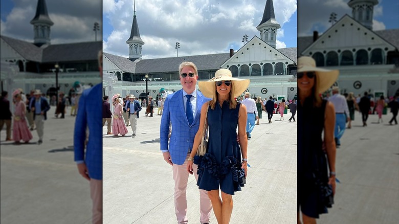 Martha MacCallum smiling while wearing a dark blue short dress, yellow sun hat, and glasses, next to her husband Daniel John Gregory who's wearing a light blue suit and tan khakis.