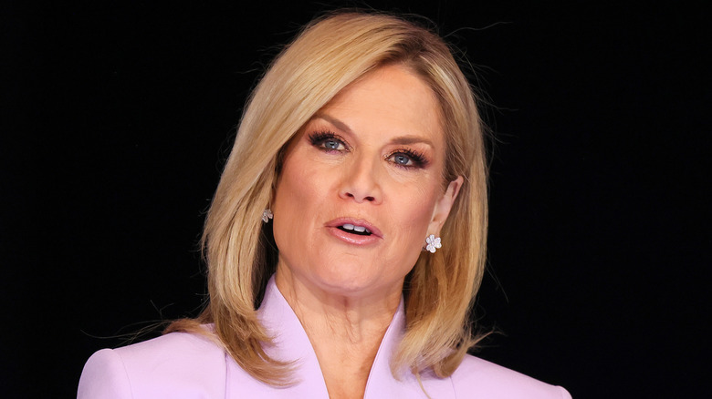 Martha MacCallum wearing a light purple blazer while reporting the news.