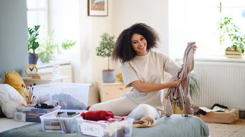 Woman holding sweater and smiling