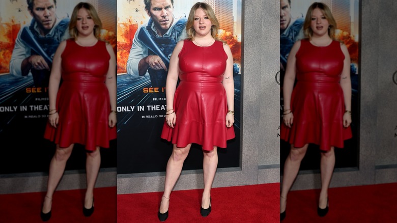Francesca Scorsese posing on the red carpet in a red leather mini dress and black heels