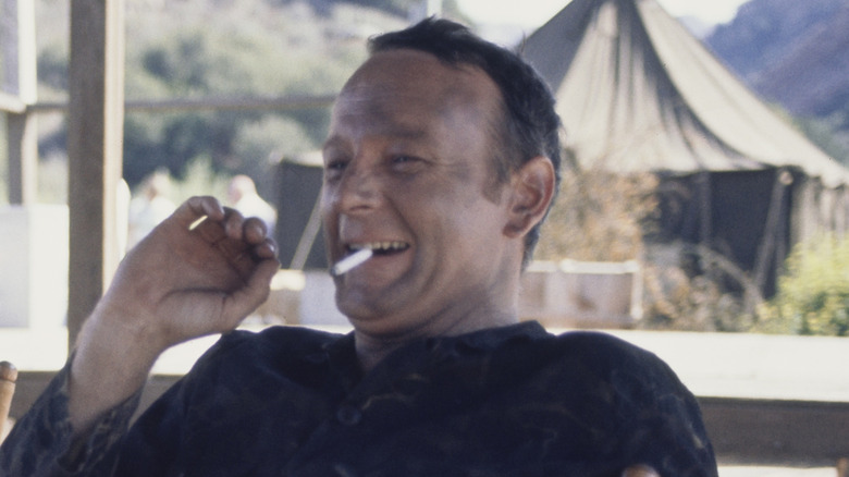 Larry Linville laughing and smoking a cigarette on set of "M*A*S*H"