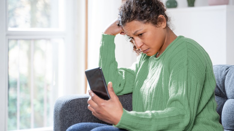 Woman looking at dating app on her phone