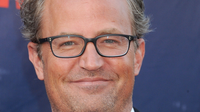 Matthew Perry smiles with glasses