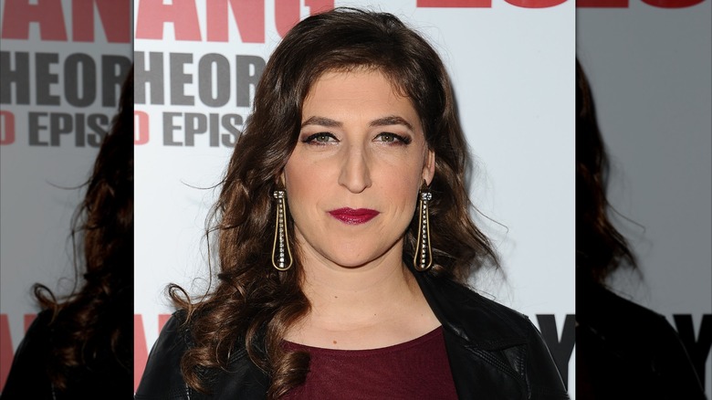 Mayim Bialik posed in a maroon shirt and black leather jacket