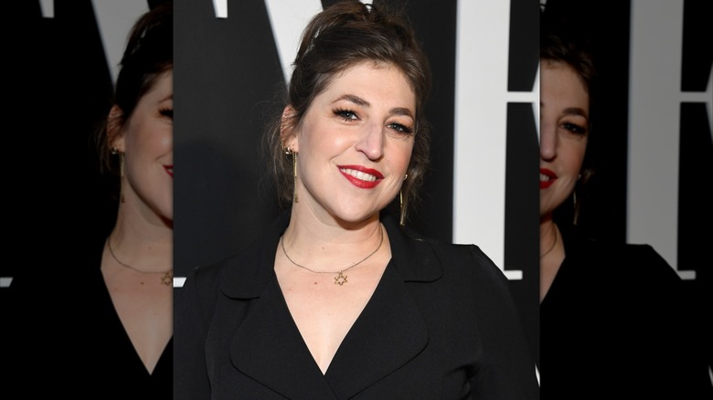 Mayim Bialik smiles in a black blazer