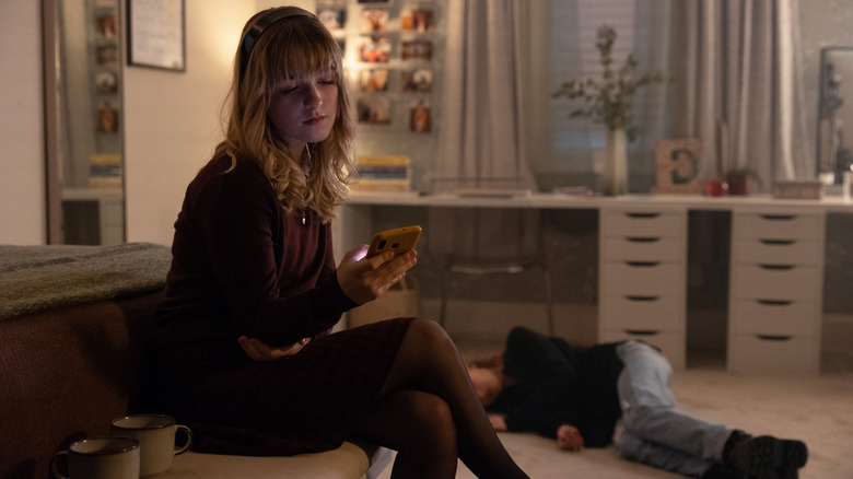 Mckenna Grace looking at her phone in The Bad Seed Returns