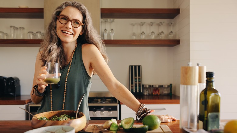 woman cooking and drinking smoothie