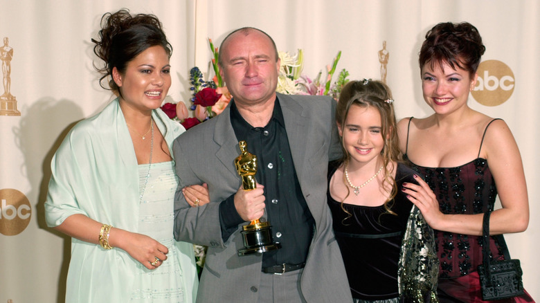 Phil Collins posing with his third wife, Orianne, and daughters Lily and Joely in 2000