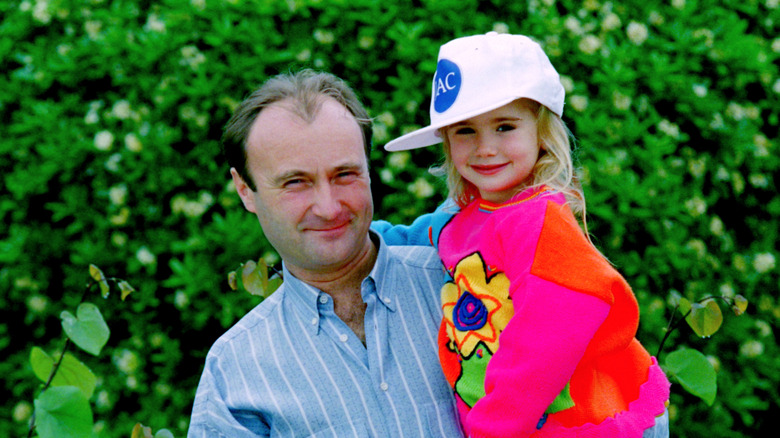 Phil Collins and Lily Collins posing for a photo in 1988.