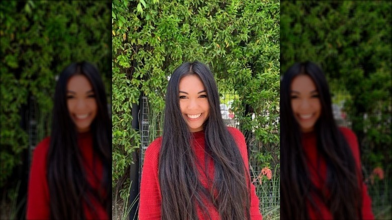 Athena Bautista smiling in front of grass wall