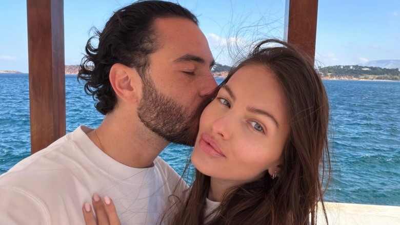 Thylane Blondeau embracing Ben Attal, who's kissing her cheek