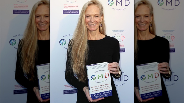 Suzy Amis posing with her OMD book