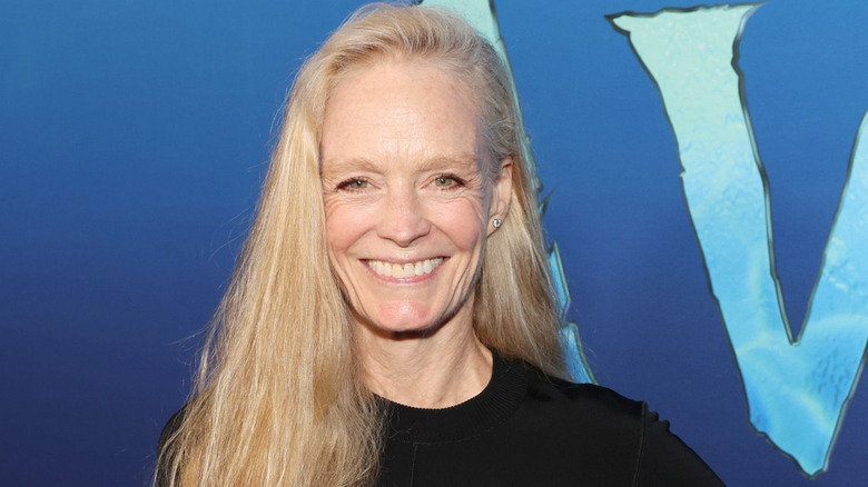 Suzy Amis posing in front of a blue Avatar background